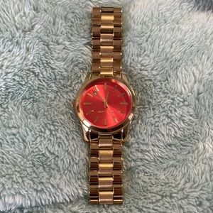 Michael kors gold stainless steel watch with orange face.